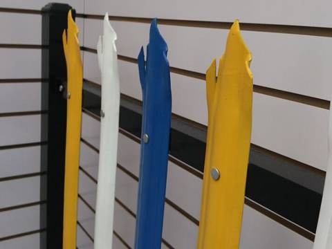 W profile palisade fence painted with yellow, blue and white colors fastened on the black