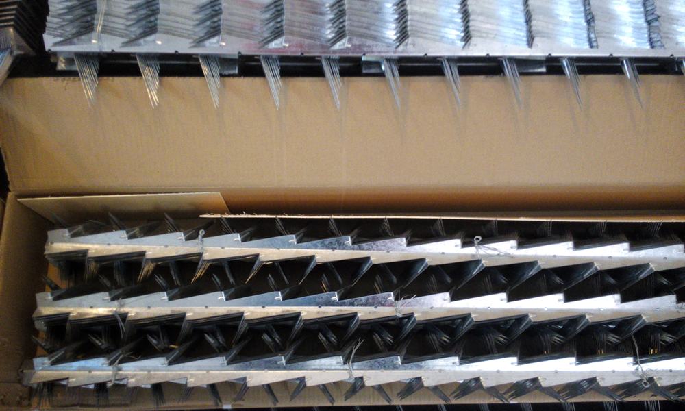 Several rows of galvanized small size wall spikes stack together and packaged into the cardboard box.