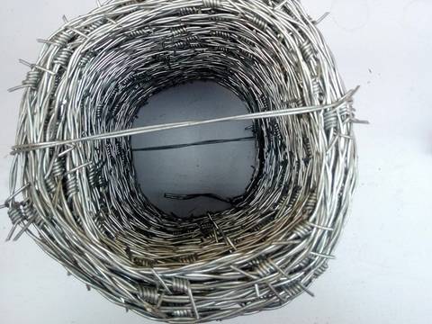The top view of a coil of stainless steel barbed wire, which is fastened by stainless steel wire on the floor.