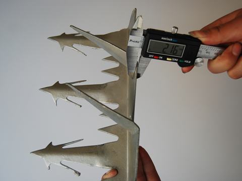 A hand is measuring plate thickness of wall spike.